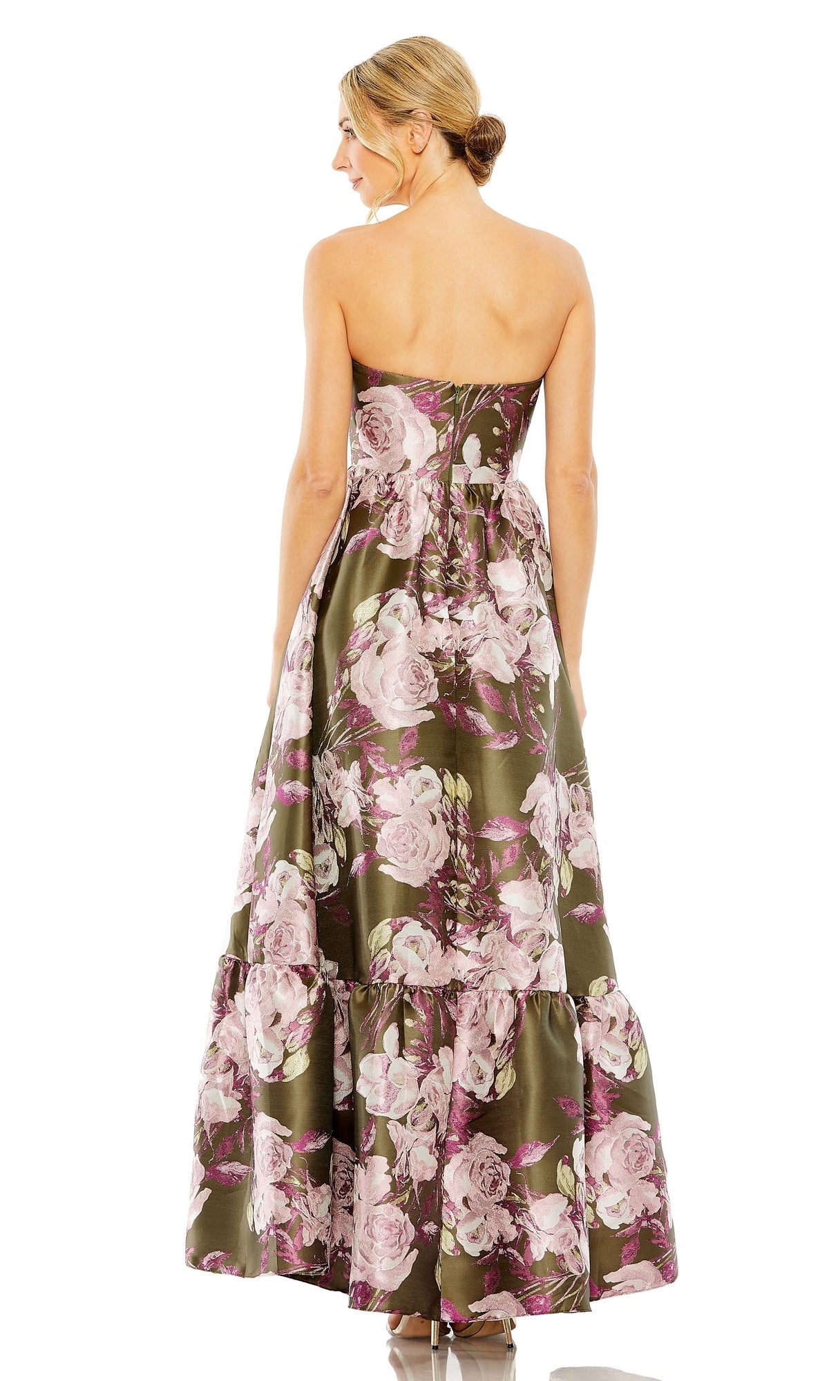 A woman with blonde hair in a low bun models the Mac Duggal 11605 Green Floral-Print Formal Dress, shown from the back against a white background.